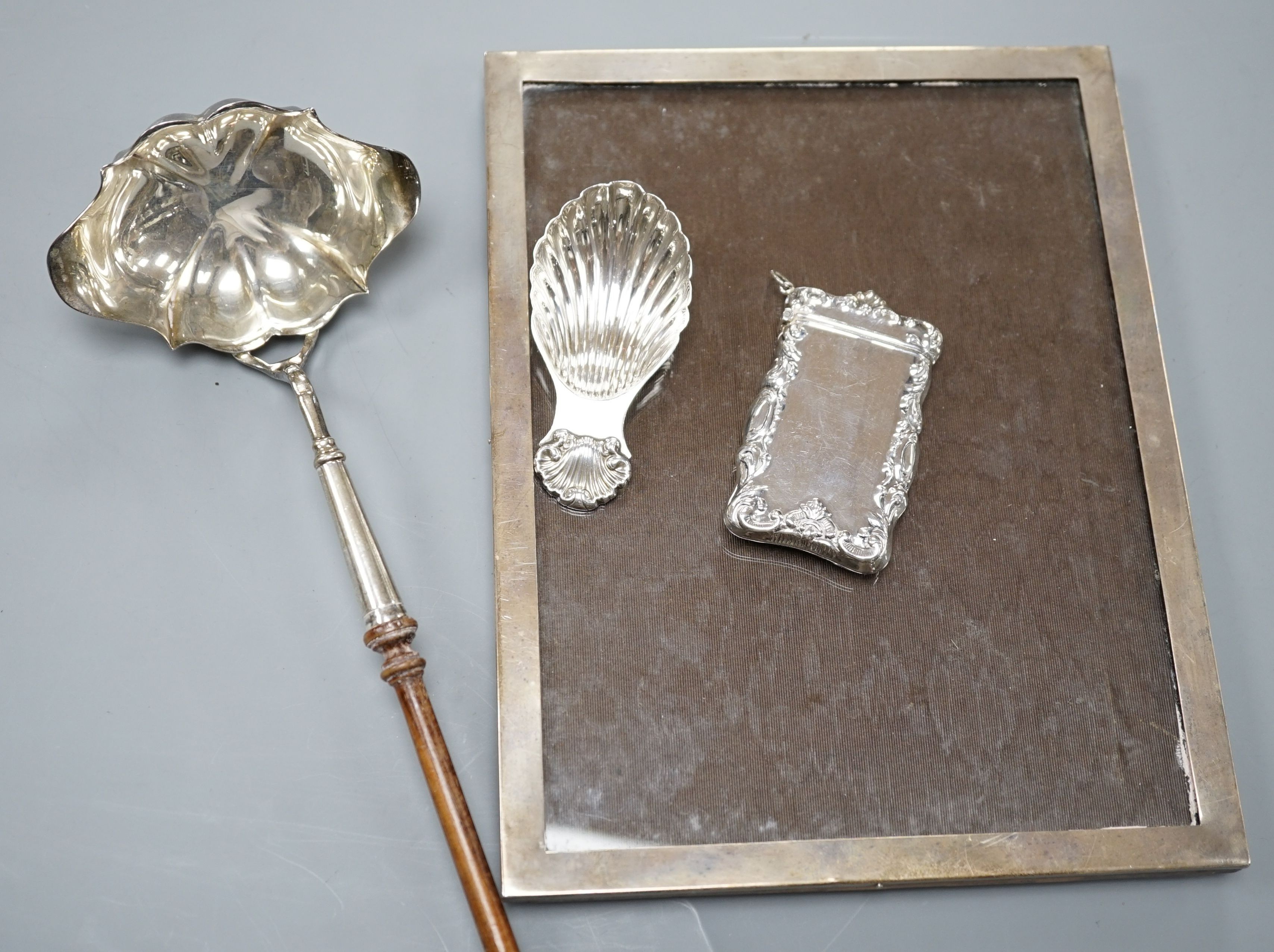 A Georgian style silver toddy ladle, London 1976, a silver mounted rectangular photograph frame, a caddy spoon, and a vesta case stamped Sterling